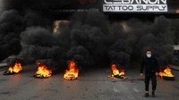 Para pengunjuk rasa menutup jalan dengan cara membakar ban. Bukan hanya di Beirut, penutupan jalan utama juga terjadi di kota lain di Lebanon.