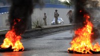 Tentara Lebanon berjaga di depan ban yang terbakar menghalangi jalan raya utama yang mengarah ke bandara internasional Beirut.