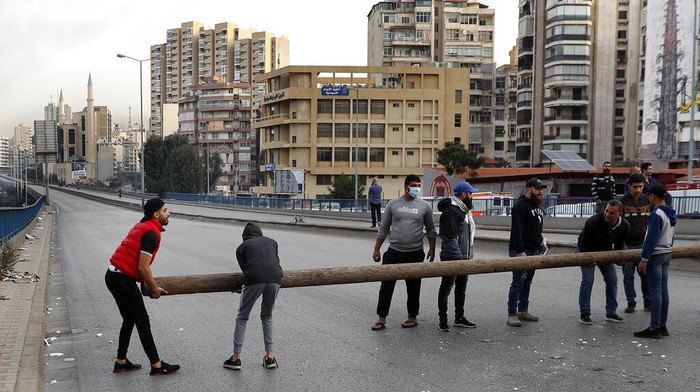 Sejumlah demonstran memblokade jalan utama di sejumlah jalur Ibu Kota Lebanon, Beirut. Ini merupakan salah satu aksi kemarahan warga di tengah krisis ekonomi, Senin, (29/11/2021). (AP Photo/Hussein Malla)