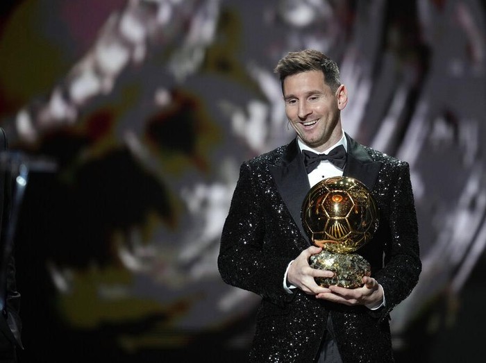 PSG player Lionel Messi receives the 2021 Ballon d'Or trophy from his former Barcelona teammate Luis Suarez during the 65th Ballon d'Or ceremony at Theatre du Chatelet, in Paris, Monday, Nov. 29, 2021. (AP Photo/Christophe Ena)