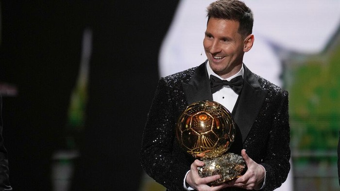 PSG player Lionel Messi receives the 2021 Ballon dOr trophy from his former Barcelona teammate Luis Suarez during the 65th Ballon dOr ceremony at Theatre du Chatelet, in Paris, Monday, Nov. 29, 2021. (AP Photo/Christophe Ena)