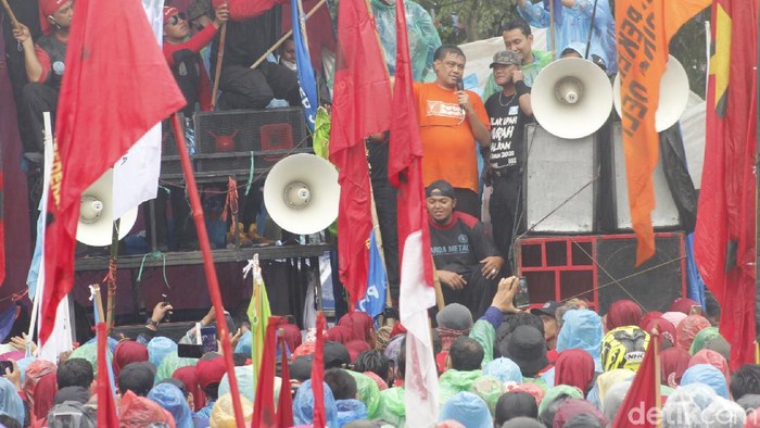 Demo buruh di Jawa Barat berlangsung di depan Gedung Sate. Orasi soal UMP terebut dilakukan meski hujan deras mengguyur.