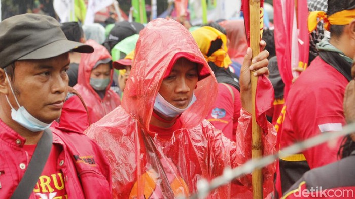Demo buruh di Jawa Barat berlangsung di depan Gedung Sate. Orasi soal UMP terebut dilakukan meski hujan deras mengguyur.