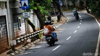 Sumur resapan yang dipasang di pinggir jalan membuat pengendara sepeda motor dan mobil terpaksa melintas condong ke tengah jalan. 