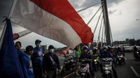 Ratusan buruh konvoi melintasi Jembatan Pasupati saat melakukan aksi di Bandung, Senin (29/11/2021). Aksi buruh yang tergabung dari berbagai aliansi di Jawa Barat tersebut ditujukan untuk mengawal penetapan UMK oleh Pemprov Jabar. ANTARA FOTO/Raisan Al Farisi  