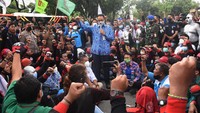 Gubernur DKI Jakarta Anies Baswedan (tengah) berorasi saat menemui buruh yang berunjuk rasa menolak besaran kenaikan Upah Minimum Provinsi (UMP) di depan Balai Kota DKI Jakarta, Senin (29/22/2021). ANTARA FOTO/Indrianto Eko Suwarso  