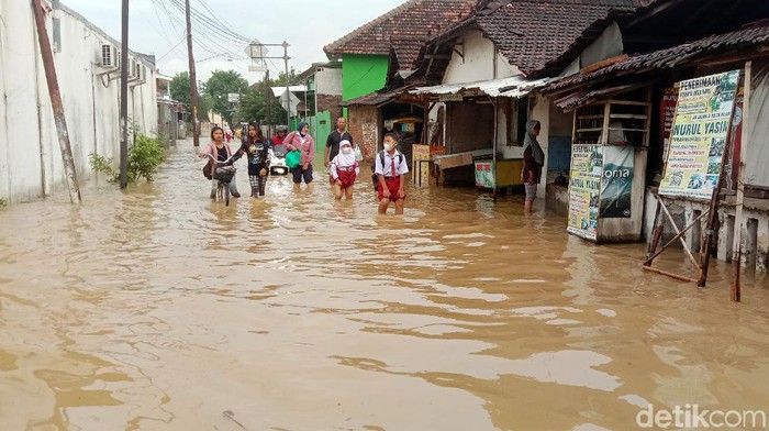 Hujan deras terjadi semalam menyebabkan tanggul Sungai Dawe di wilayah Kecamatan Mejobo, Kabupaten Kudus, Jawa Tengah jebol, Selasa (30/11/2021). Permukiman warga hingga akses jalan terpantau terendam banjir pagi ini.