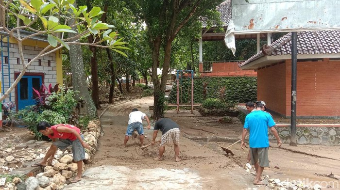 Warga Wonosoco, Undaan, Kudus gotong royong membersihkan sisa lumpur banjir bandang. Hujan deras mengakibatkan sungai di Wonosoco meluap dan menimbulkan banjir bandang, Senin (29/11/2021).