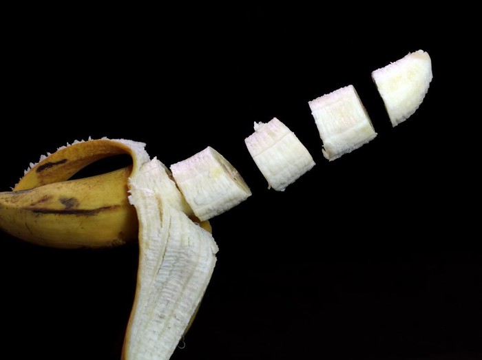 banana with open skin in the tossed state on a dark background