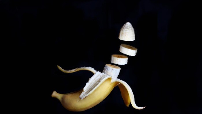 banana with open skin in the tossed state on a dark background