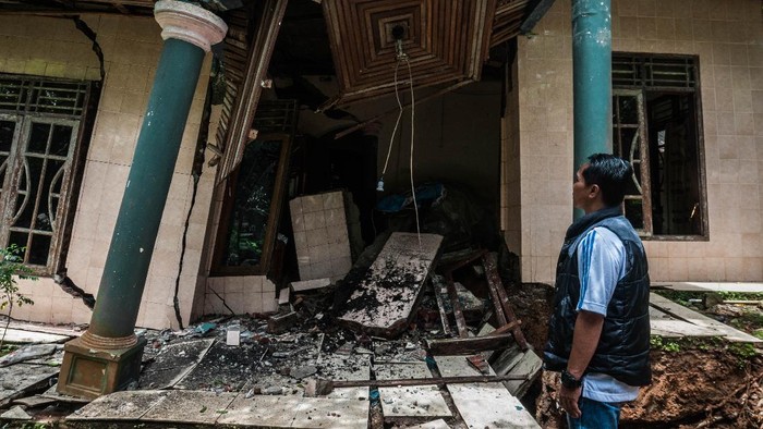 Pemilik rumah melihat kondisi rumahnya yang rusak akibat pergerakan tanah di Desa Cikotok, Lebak, Banten, Rabu (1/12/2021). Curah hujan yang tinggi selama tiga hari di daerah itu menyebabkan delapan rumah di Desa Cikotok rusak akibat pergerakan tanah, dua di antaranya rusak berat dan mengakibatkan 11 kepala keluarga mengungsi. ANTARA FOTO/Muhammad Bagus Khoirunas/wsj.