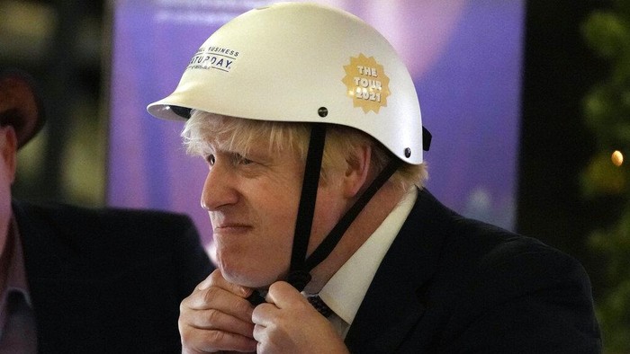Britains Prime Minister Boris Johnson puts on a helmet to ride a bicycle as he attends a UK Food and Drinks market set up in Downing Street in London, Tuesday, Nov. 30, 2021.(AP Photo/Frank Augstein)