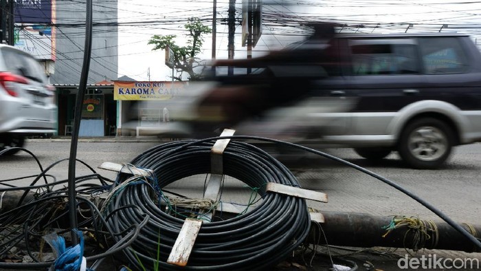 Sebuah tiang melintang di Jalan Cinere Raya, Depok, Jawa Barat. Keberadaan tiang itu dapat membahayakan para pengguna jalan.