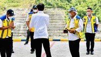 Setelah membeli sepatu bot dan baju batik, Presiden, Menteri PUPR, Mensesneg, dan Bupati Trenggalek meninggalkan Kantor Pengelola Bendungan Tugu. Tampak Menteri PUPR menenteng sepatu yang dipilihnya, bahkan saat foto bersama pun masih menenteng sepatu.
