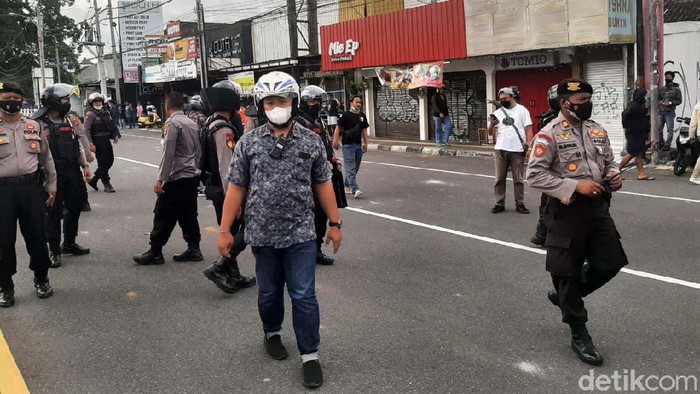 Bentrokan terjadi antara suporter bola dengan warga di Jalan Laksda Adisutjipto, Yogyakarta, siang tadi. Puluhan polisi masih berjaga di lokasi.