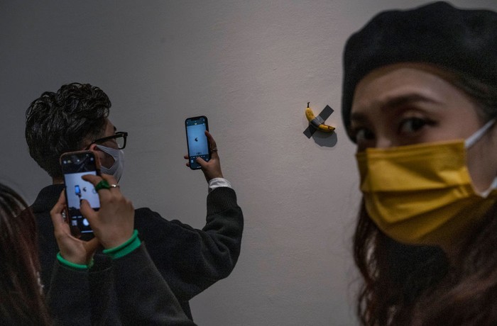 Wuih! Karya Seni Pisang Dilakban Mejeng Lagi, Diserbu Warga Beijing BEIJING, CHINA - NOVEMBER 28: Visitors take pictures of the work