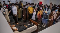 Ada juga dua orang laki-laki tampak tiduran di atas kasur. Karya seni instalasi itu berjudul We. Foto: Getty Images/Kevin Frayer
