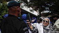 Sebagian massa sempat berfoto-foto dengan petugas kepolisian sebelum membubarkan diri.