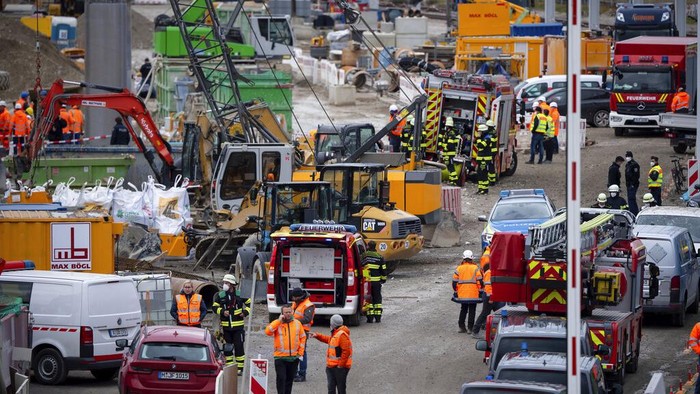 Germany Explosion Firefighters go to an S-Bahn together with railway staff at a railway site in Munich, Germany, Wednesday, Dec. 1, 2021. Police in Germany say three people have been injured including seriously in an explosion at a construction site next to a busy railway line in Munich. (Sven Hoppe/dpa via AP)