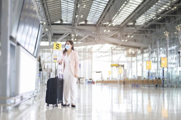 Ilustrasi wanita menggunakan masker di bandara
