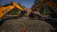 Ekskavator dikerahkan untuk menguburkan gajah liar yang mati ditabrak kereta di India.