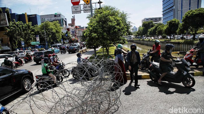 Sejumlah pegendara motor menerobos pembatas kawat duri di kawasan Jalan Juanda Jakarta Pusat, Kamis (2/12). Penutupan jalan untuk mengantisipasi kegiatan Reuni 212.