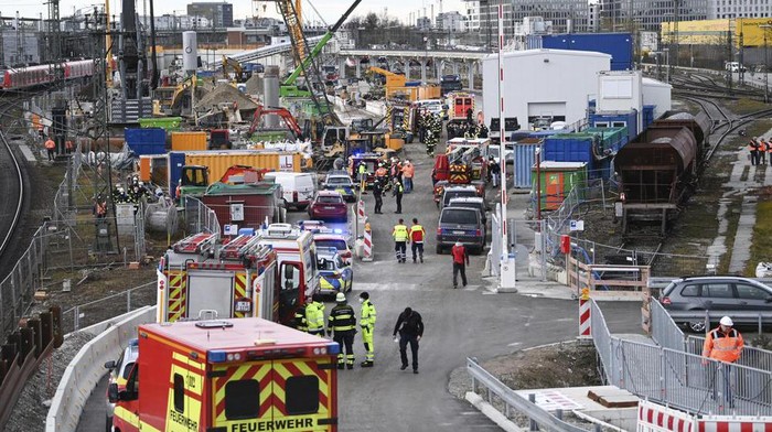 Firefighters, police officers and railway employees stand on a railway site in Munich, Germany, Wednesday, Dec. 1, 2021. Police in Germany say three people have been injured including seriously in an explosion at a construction site next to a busy railway line in Munich. (Sven Hoppe/dpa via AP)