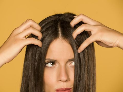 Asian woman hair having problem with dandruff hand itching her dry skin on head