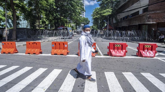 Reuni 212 Tidak Dapat Izin, Massa Berkumpul-Polisi Lakukan Penyekatan Salah satu peserta reuni 212 berjalan melewati barikade penyekatan guna mengantisipasi membludaknya massa reuni 212 di kawasan Sarinah Thamrin, Jakarta, Kamis (2/12/2021). Pihak kepolisian melakukan penyekatan disejumlah wilayah karena pelaksanaan reuni 212 dapat meningkatkan risiko penyebaran virus COVID-19. ANTARA FOTO/Muhammad Adimaja/hp.
