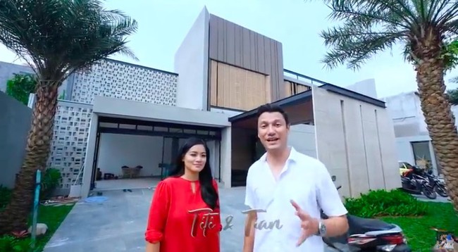 Inilah penampakan depan rumah baru Titi Kamal dan Christian Sugiono. Dari luar, tampak rumah tersebut hadir dalam arsitektur bergaya modern-kontemporer dengan sentuhan tropis. (Foto: YouTube/Titi dan Tian)