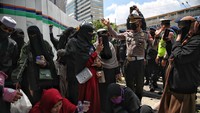 Petugas polisi secara persuasif meminta massa aksi 212 untuk membubarkan diri.