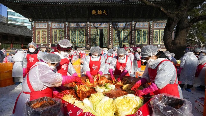 Volunteers make kimchi, a traditional pungent vegetable dish, to donate to needy neighbors, at a temple in Seoul, South Korea, Thursday, Dec. 2, 2021. About 200 people made 4,000 packets of kimchi, made primary with cabbage, other vegetables and chili sauce. Kimchi is the most popular traditional food in Korea. (AP Photo/Ahn Young-joon)