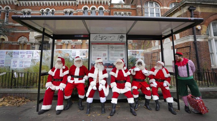 Pria berpakaian Sinterklas berjalan selama Sekolah Santa, di Ministry of Fun, di London, Selasa, 30 November 2021. Sekolah tahun ini akan mencakup pelatihan tatap muka dan digital. Panggilan video yang dipersonalisasi melalui platform Santa HQ tetap populer meskipun gua dibuka kembali. Ministry of Fun mengalami tahun tersibuk mereka untuk pengalaman Natal. (AP Photo/Kirsty Wigglesworth)