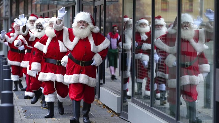 Pria berpakaian Sinterklas berjalan selama Sekolah Santa, di Ministry of Fun, di London, Selasa, 30 November 2021. Sekolah tahun ini akan mencakup pelatihan tatap muka dan digital. Panggilan video yang dipersonalisasi melalui platform Santa HQ tetap populer meskipun gua dibuka kembali. Ministry of Fun mengalami tahun tersibuk mereka untuk pengalaman Natal. (AP Photo/Kirsty Wigglesworth)