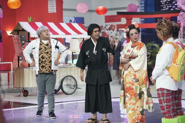 Rambut Soimah tampak tersanggul rapih ala wanita Jepang. Pada bagian kiri dan kanan rambutnya dihiasi dengan bunga yang berwarna-warni. Pipinya tampak merah merona dan bibirnya pun dipulas dengan lipstik berwarna merah. Foto: Instagram/@showimah