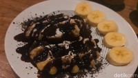 Waffle dengan topping kekinian juga tersedia di sini. Disajikan dengan topping saus cokelat dan remahan Oreo serta irisan pisang. Foto: detikFood / Yenny Mustika Sari