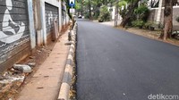 3 Desember, jalanan ini sudah mulus ditutup aspal. Lantas apa kabar sumur resapan? Di mana pula lubang airnya? Bukankah sumur resapan dibangun untuk menyerap air di permukaan jalan ini? Kalau tidak ada lubang air, bagaimana air bisa masuk sumur resapan? (Marteen Ronaldo Pakpahan/detikcom)