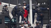 Foto-foto yang beredar menunjukkan para polisi bersenjata mengelilingi pria itu saat dia mondar-mandir di trotoar sambil menenteng shotgun selama lebih dari dua jam.