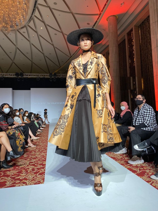 Gunakan aksesori sederhana seperti anting kecil, jam tangan elegan, sabuk atau clutch polos agar motif wastra tetap dominan. Seperti ditampilkan di koleksi desainer Denny Wirawan. (Foto: Dok. JFW 2026)