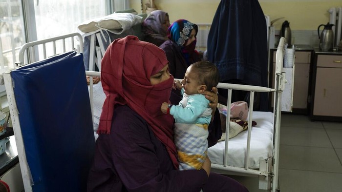 Krisis Kemanusiaan Afghanistan Seorang ibu menggendong bayinya saat menjalani perawatan di bangsal gizi buruk Rumah Sakit Anak Nasional Ataturk di Kabul, Afghanistan, Kamis, 2 Desember 2021. Menurut angka PBB dari awal November, hampir 24 juta orang di Afghanistan, sekitar 60% persen dari populasi, menderita kelaparan akut, termasuk 8,7 juta yang tinggal di dekat kelaparan. (Foto AP/Petros Giannakouris)