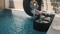 Berada di sebuah hotel, Laura sempat menikmati floating breakfast. Ia terlihat menikmati segelas jus jeruk, salad, dan buah segar. Foto: Instagram @edlnlaura