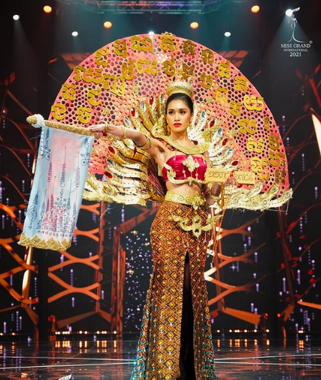 Miss Grand Cambodia Sothida Pokimtheng juga masuk ke dalam Top 10 best national costume. Ia tampil heboh dengan aksen kipas di bagian belakangnya. Foto: Miss Grand International 2021