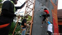 Seoranhg difabel berusaha memanjat tebing dengan dibantu pemanjat dinding difabel Sabar Gorky.