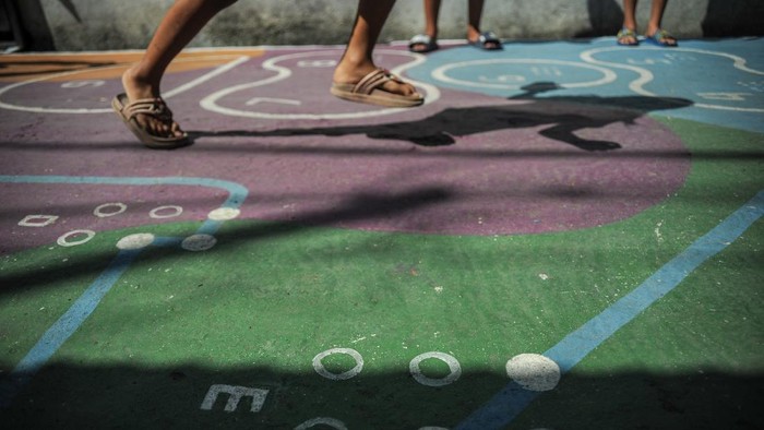 Sejumlah anak bermain permainan tradisional yang dilukis di Gang Sayuran 2, Jalan Gempolsari, Bandung, Jawa Barat, Kamis (2/12/2021). Karangtaruna 02 Gempolsari berinisiatif melukis Gang Sayuran 2 dengan permainan tradisional yang memuat unsur huruf dan angka braille guna mewujudkan lingkungan yang lebih edukatif. ANTARA FOTO/Raisan Al Farisi/foc.