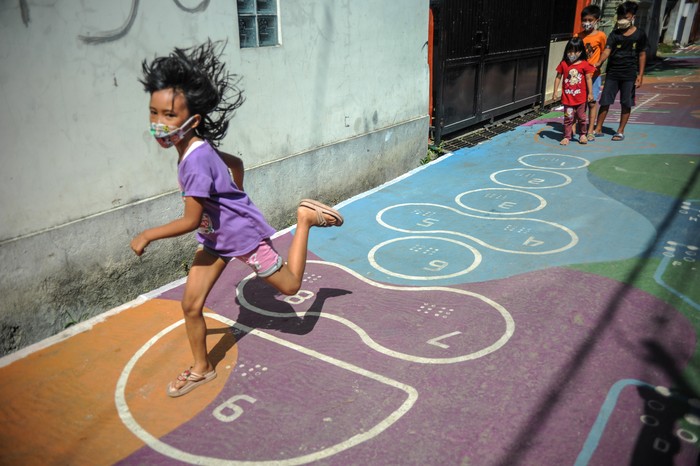 Sejumlah anak bermain permainan tradisional yang dilukis di Gang Sayuran 2, Jalan Gempolsari, Bandung, Jawa Barat, Kamis (2/12/2021). Karangtaruna 02 Gempolsari berinisiatif melukis Gang Sayuran 2 dengan permainan tradisional yang memuat unsur huruf dan angka braille guna mewujudkan lingkungan yang lebih edukatif. ANTARA FOTO/Raisan Al Farisi/foc.