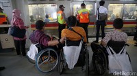 Penyandang disabilitas menunggu kereta berhenti.