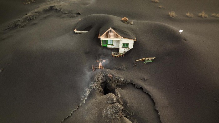 A soccer field is covered with ash from the volcano on the Canary island of La Palma, Spain, Wednesday, Dec. 1, 2021. A fresh stream of lava from volcano on Spain's La Palma threatened on Wednesday to engulf a parish church that has so far survived the eruption that shows no signs of relenting in its tenth week. (AP Photo/Emilio Morenatti)