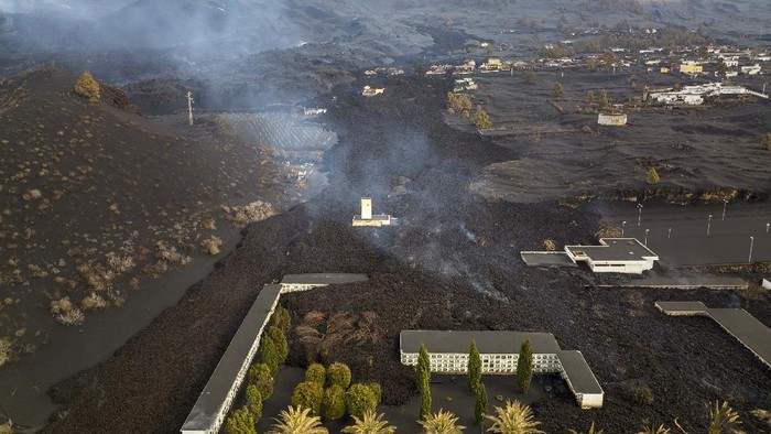 Potret Pemukiman yang Terkubur Abu Gunung Berapi di Spanyol A soccer field is covered with ash from the volcano on the Canary island of La Palma, Spain, Wednesday, Dec. 1, 2021. A fresh stream of lava from volcano on Spain's La Palma threatened on Wednesday to engulf a parish church that has so far survived the eruption that shows no signs of relenting in its tenth week. (AP Photo/Emilio Morenatti)
