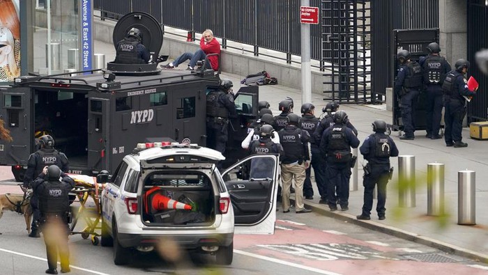 NYPD emergency services officers respond to a man standing outside United Nations headquarters with a shotgun, Thursday, Dec. 2, 2021, in New York. Hostage negotiators spoke to the man who appeared to be in his 60s, and hoped to resolve the situation peacefully. (AP Photo/John Minchillo)