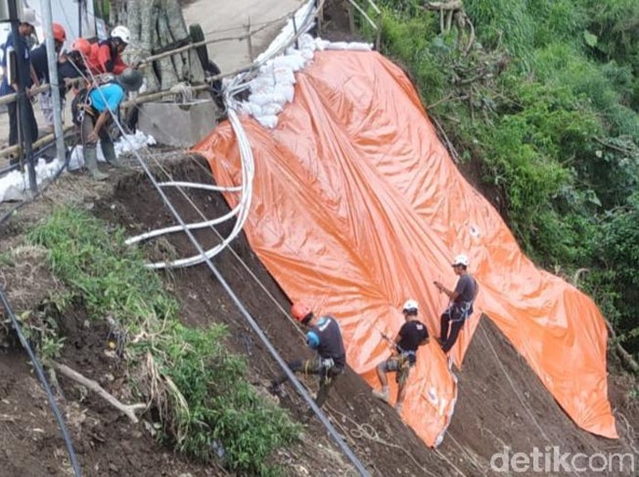 Tim SAR gabungan menutup longsor tebing di Dusun Pajegan, Desa Tegalmulyo, Klaten dengan terpal, Jumat (3/12/2021).